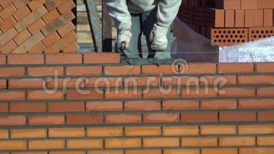 工人砌一堵砖墙. 建筑物上的建筑工人进行砌砖。 建筑工地的建筑工人